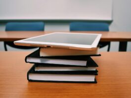 silver ipad on stack of books